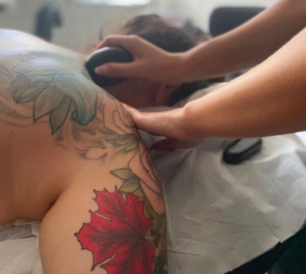 Hot stone massage on a client's shoulders