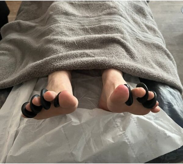 Hot stones placed between a client's toes