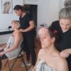 Students practising Indian head massage in a training room