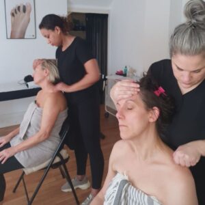 Students practising Indian head massage in a training room
