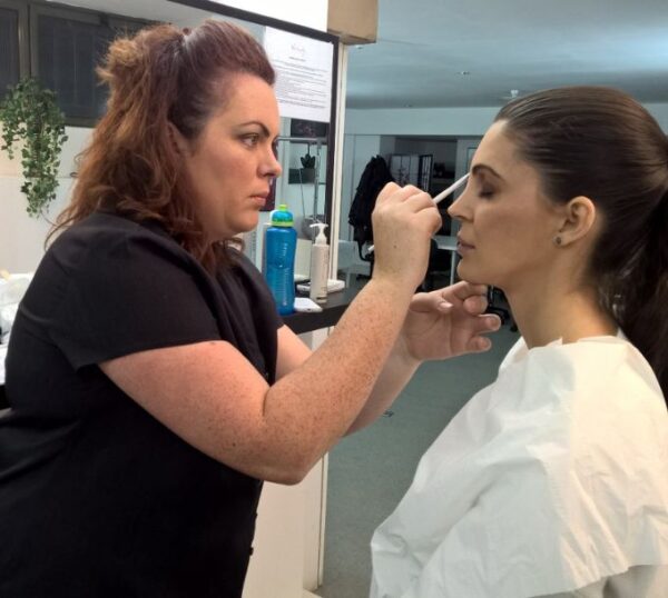 Make-up artist applying make-up to a model during training