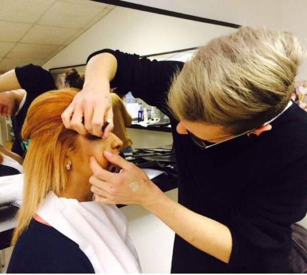 Make-up artist styling a model's hair and make-up