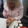 Student applying UV gel nail extensions