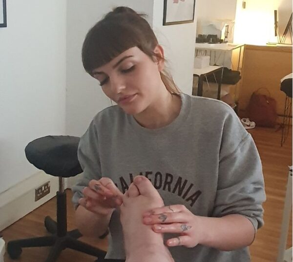 Student practising reflexology in a training room