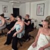 Students practising massage on each other in a training room