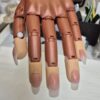 Acrylic nail extensions on a practice hand