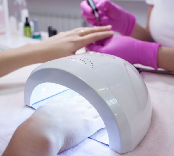Gel nails being cured under a UV lamp