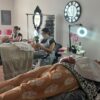 Students practising electrical facials in a training room