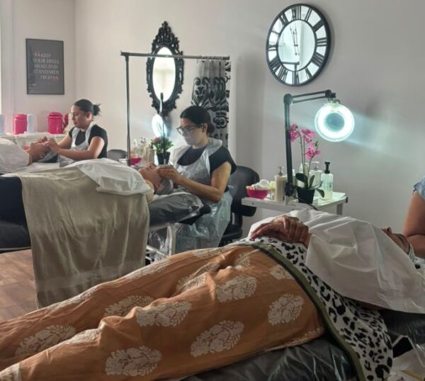 Students practising electrical facials in a training room