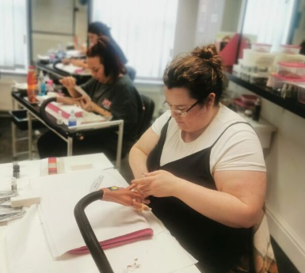Students practising nail extensions in class