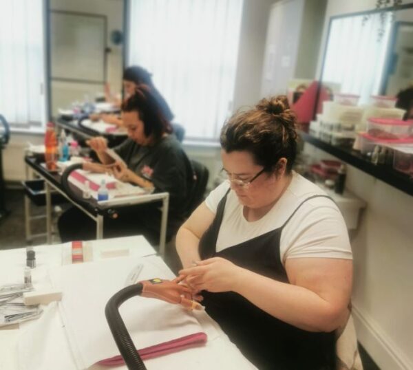 Student practising acrylic nail extensions in class