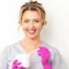 Smiling waxing therapist holding a wax spatula