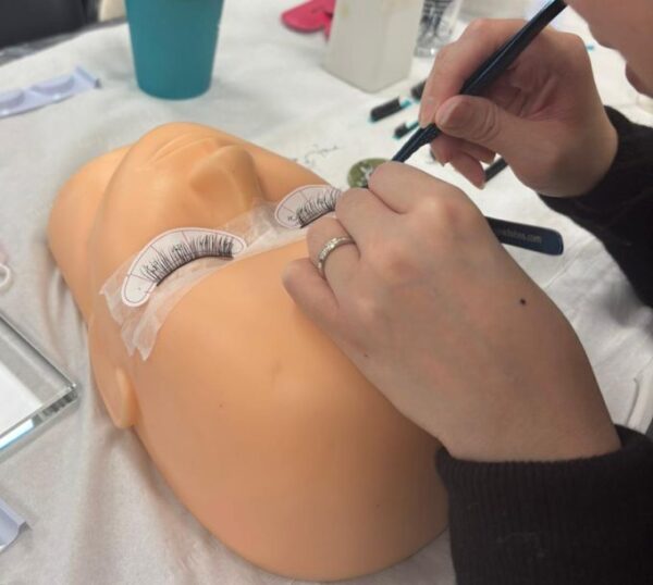 Lash extensions being applied to a practice mannequin