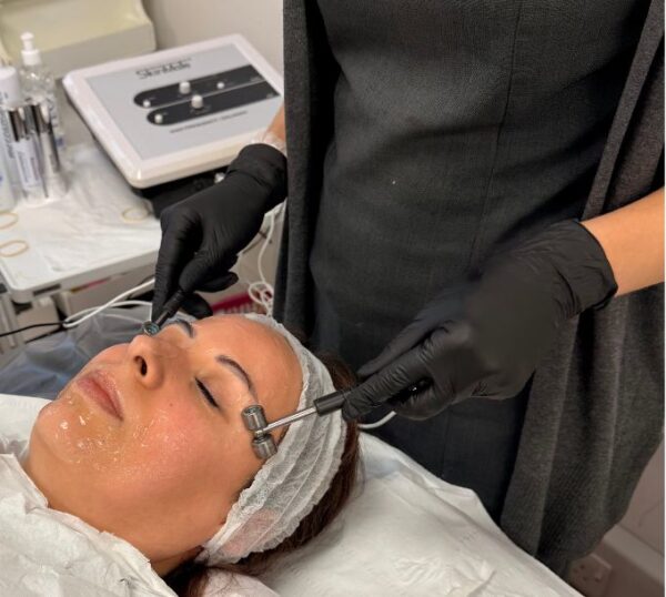 Client receiving an electrical facial treatment