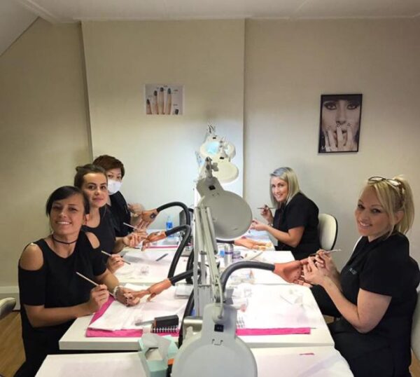 Smiling students and tutor at an acrylic nails training day