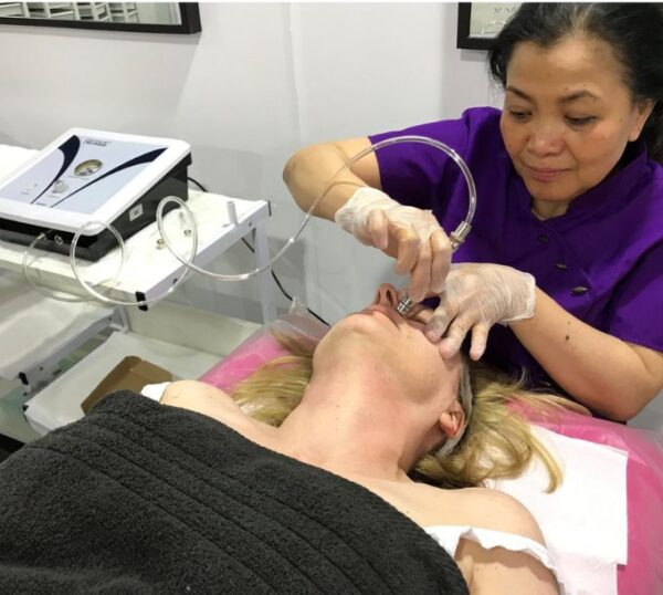 Tutor demonstrating a microdermabrasion facial