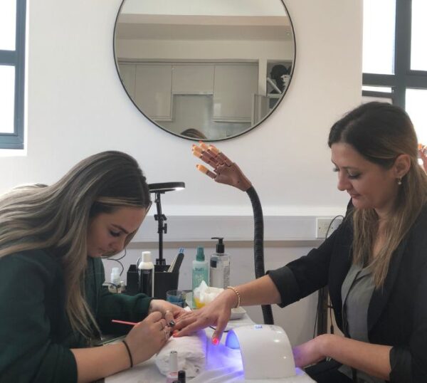 Students practising gel polish manicures
