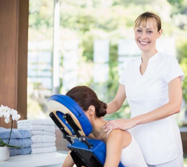 Smiling massage therapist with a client