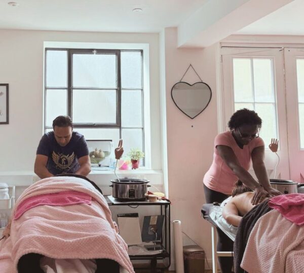 Students practising massage in a training room