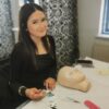 Smiling lash student with a practice mannequin head