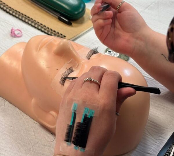 Lash extensions being applied to a practice mannequin