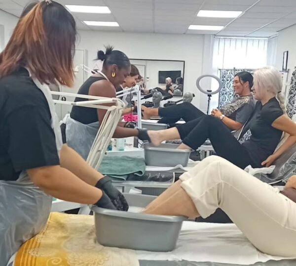 Students practising pedicures and treatments in a training room