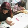 Students practising lash extensions on mannequin heads