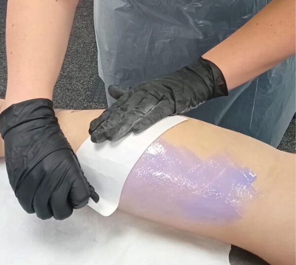 Wax strip being applied to a leg