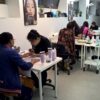 Students practising manicures at training desks