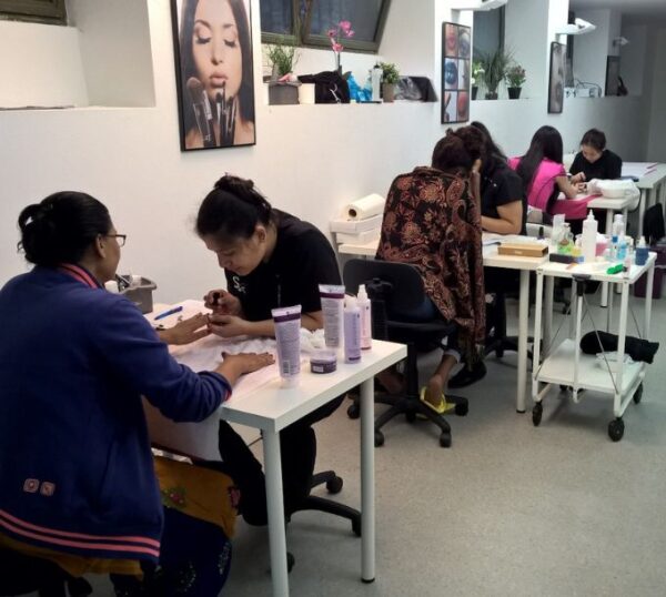 Students practising manicures at training desks