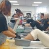 Students practising pedicures in a training room