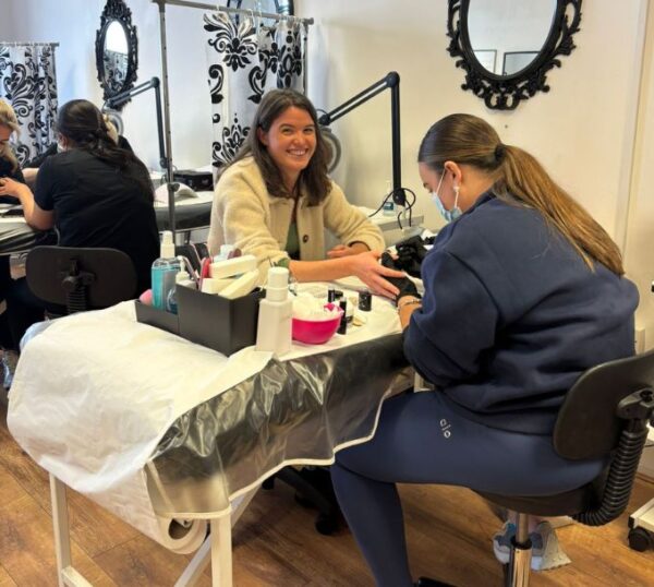 Students practising manicures in a training room