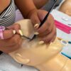 Hybrid lash extensions being applied to a practice mannequin