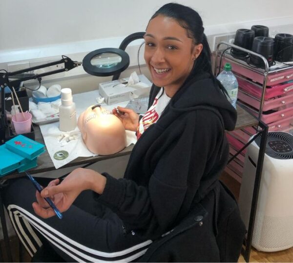 Smiling student with a practice mannequin head