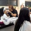 Students practising make-up on models in a training class