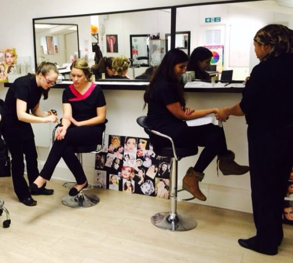 Make-up students and tutor in a Beauty Academy training room