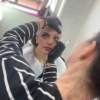 Student applying eye make-up to a model