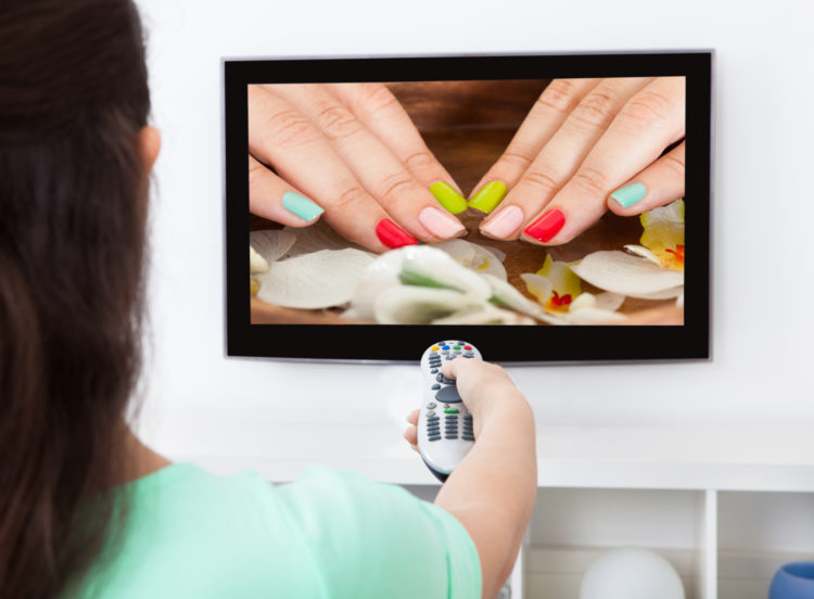 Close-up Of A Woman Holding Remote Control Changing Television Channel