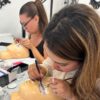 Students practising lash extensions on mannequin heads