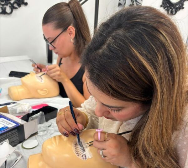 Students practising lash extensions on mannequin heads
