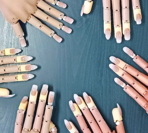 Practice hands with finished gel nail extensions
