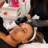Student tinting a model's brows