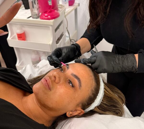 Student tinting a model's brows