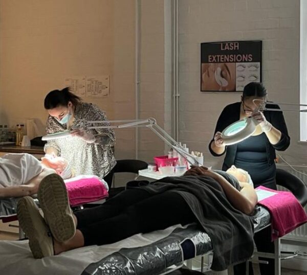 Students giving facials in a training room