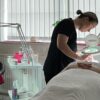 Student giving a facial in a training room