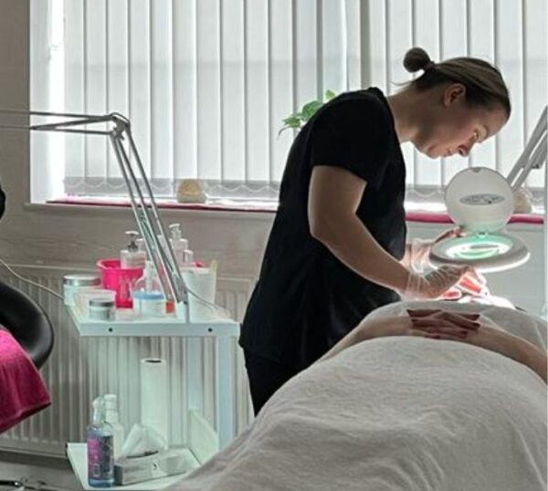 Student giving a facial in a training room