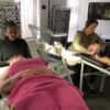 Students giving facials in a training room