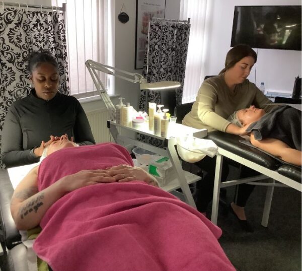 Students giving facials in a training room