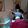 Student using a magnifying lamp during a facial