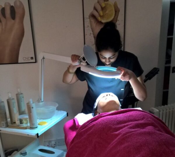 Student using a magnifying lamp during a facial